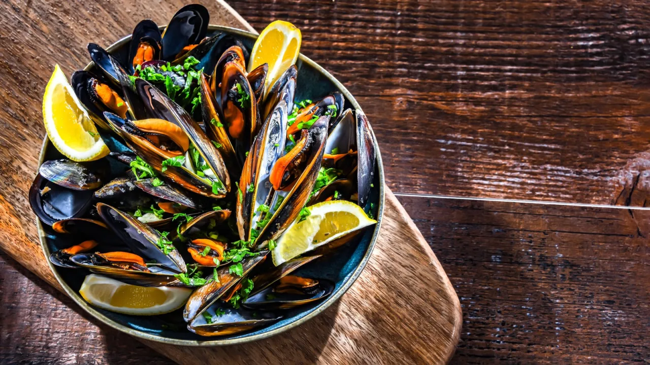 Mejillones abiertos al vapor de su propio jugo, con el limón aparte.