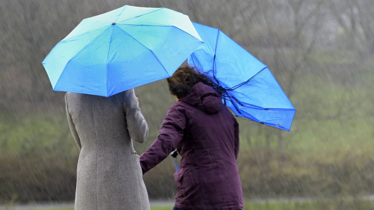 Paraguas vueltos por el viento: la borrasca entra con lluvia y rachas fuertes.