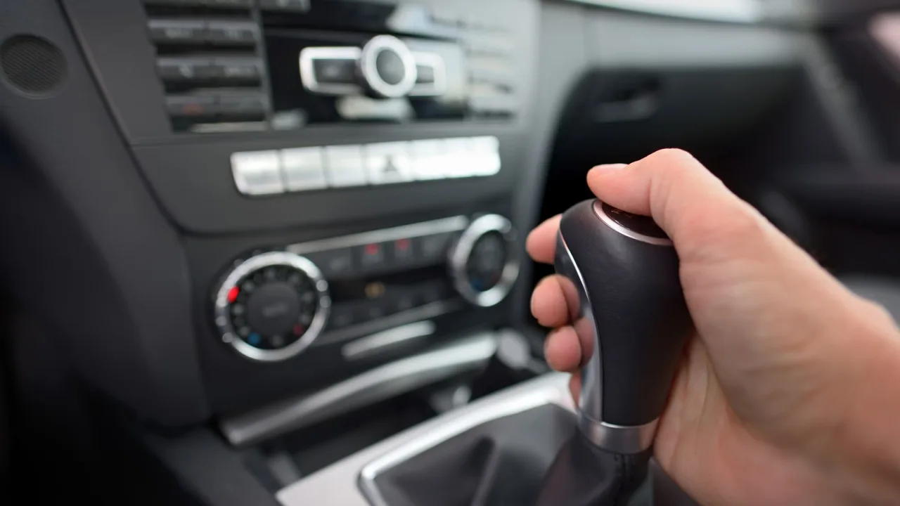 La mano va al volante, no a la palanca.
